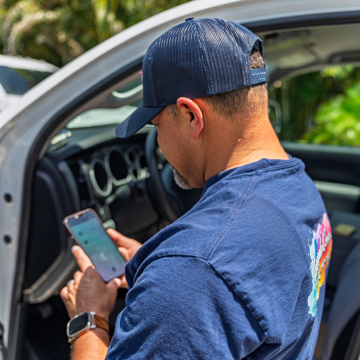 Martin of Pineapple Cove Painting Company replying to a customer text at his truck