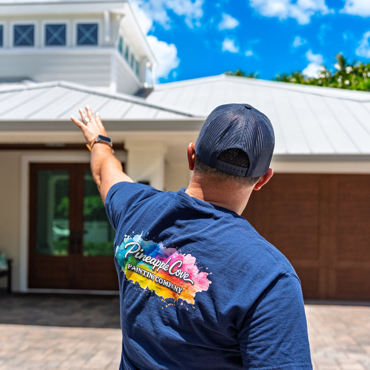 Martin Galvan of Pineapple Cove Painting Company walking a project with a homeowner and pointing out prep areas